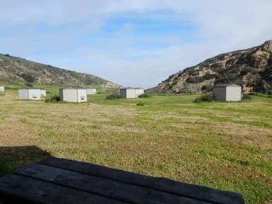 View of wide canyon with picnic table and green grass in foreground.