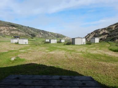 View of wide canyon with picnic table and green grass in foreground.