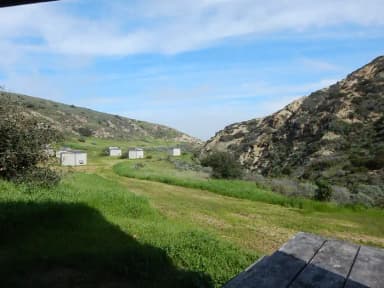 View of wide canyon with picnic table and green grass in foreground.
