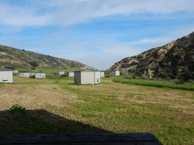 View of wide canyon with picnic table and green grass in foreground.