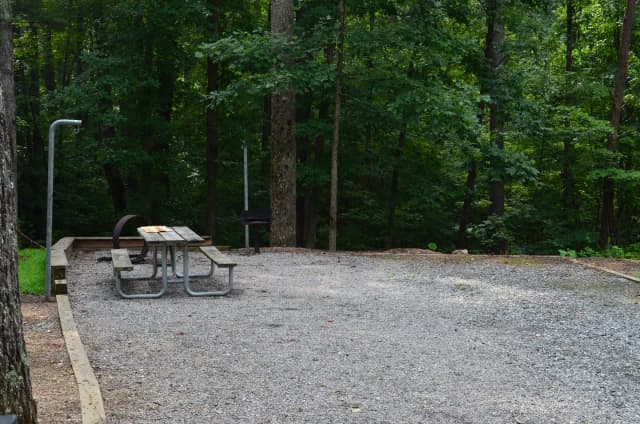 Gravel site with fire pit, table, grill