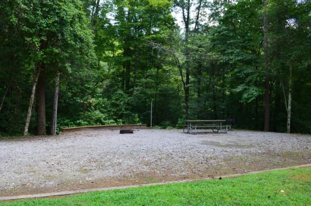 Gravel site with fire pit, table, grill
