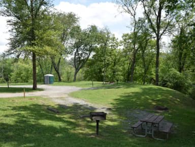 Single campsite with grill, picnic table and fire ring.