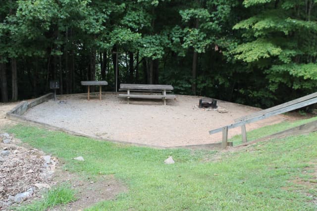 Gravel site with fire pit, table, grill