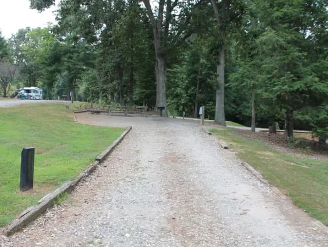 Long gravel pull in site with fire pit, table, grill