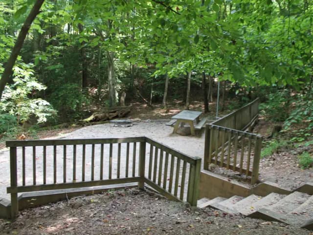 Grave site with steps leading down to table fire pit, and grill
