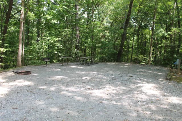 Gravel site with fire pit, table, grill