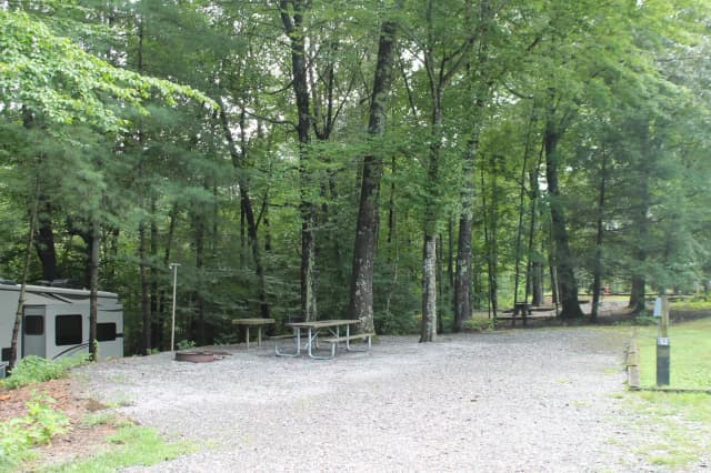 Gravel pull in and site with fire pit, table, grill