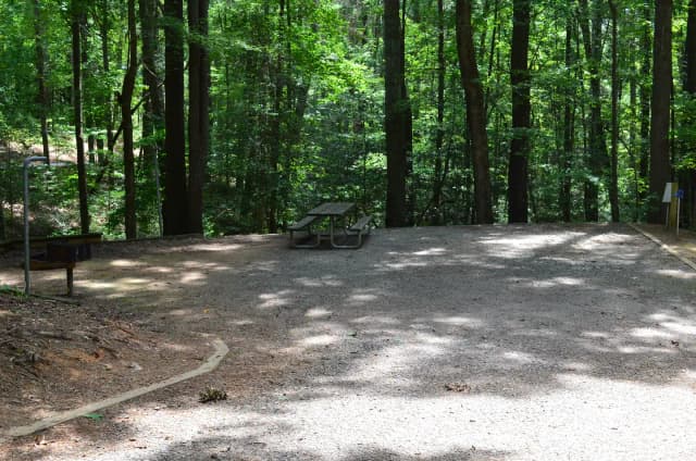 Gravel site with fire pit, table, grill