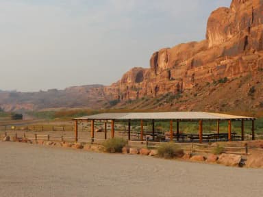 Group campsite with roof-shelter and cliffs in background.