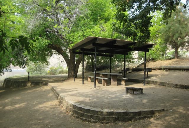 Camp site with shade shelter and fire grill.