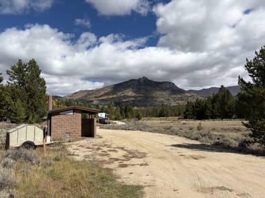 Scenic view of campground with vault toilets and trash bin