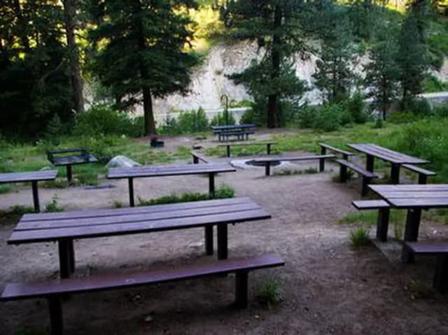 Benches and picnic tables by a sunken fire pit.