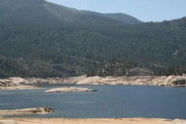 A shallow mountain lake on a blue sky day