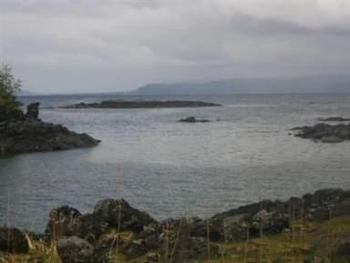 View of beach and ocean with mountains in background.