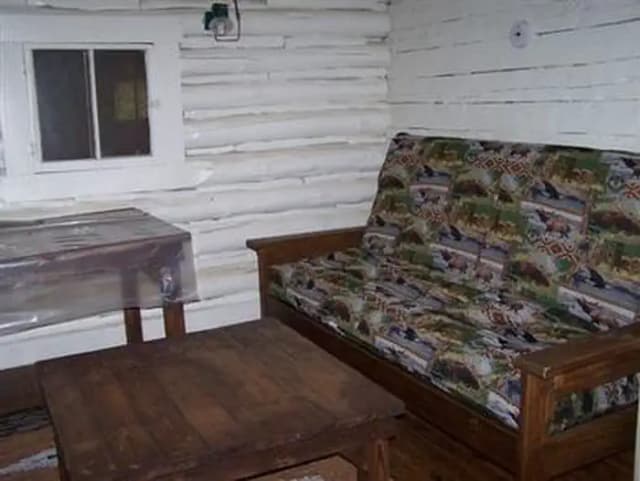 A corner of the Hull Cabin living room with two tables and a futon in the upright position.
