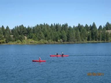 Kayakers on Hebgen Lake with pine trees in background