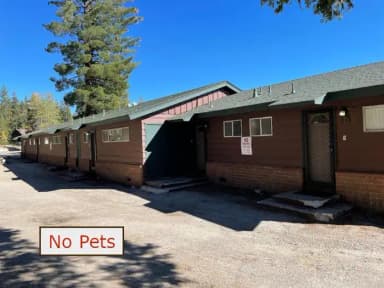 Lodge 14, row building with evergreens in the background. No Pets banner., filed by the agency against 6 campsites at Meeks Bay Resort